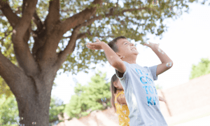 two children gleefully playing with bubbles outdoors