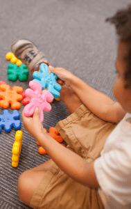 A young boy happily playing with a puzzle toy