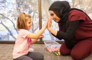 A team member and a young girl high-fiving sweetly