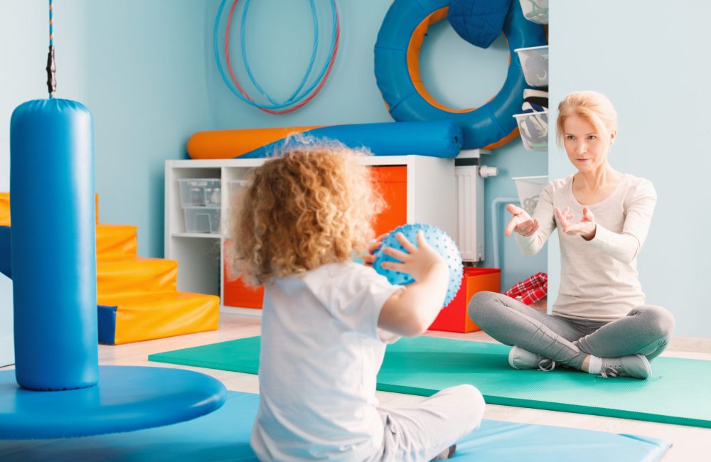 Boy playing with his therapist Boy playing with his therapist using a ball